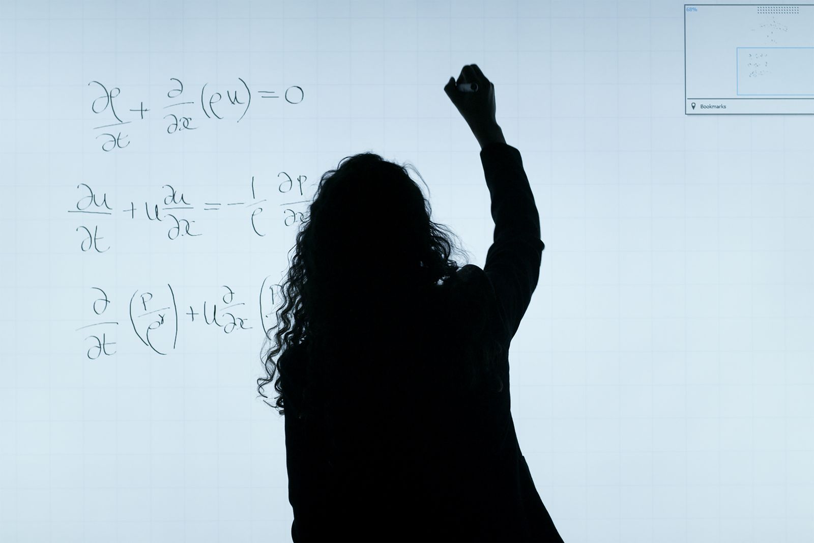 Silhouette writing formulas on a glass board